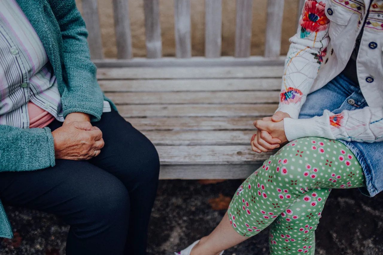 Claudia Sautter sitzt auf einer Bank neben einer zweiten Frau